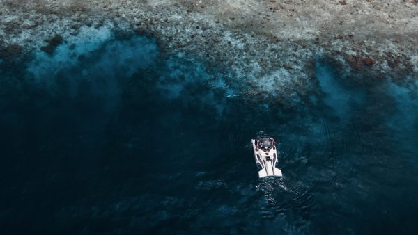 aerial view of a submersible at the surface of the ocean next to a reef in the maldives