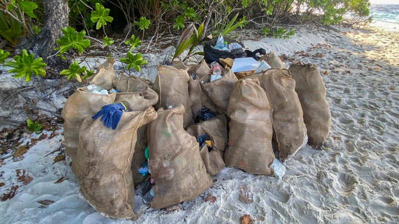 bags on a beach in the maldives - collection from a beach clean up