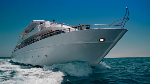view from the ocean of a large white motor yacht